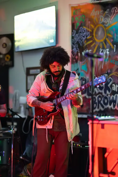 Guitarist performing in front of the graffiti mural