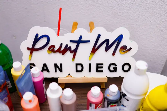 Paint Me San Diego sign surrounded by paint bottles
